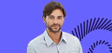 A man in an office space smiling.