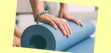 A person rolling an exercise mat.