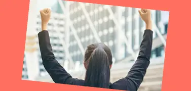 A woman in an office attire with her hands raised up.