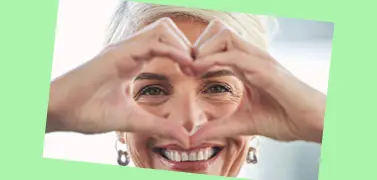 A woman with a hand gesture of love.