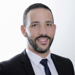 Portrait of a man in a suit and tie smiling.