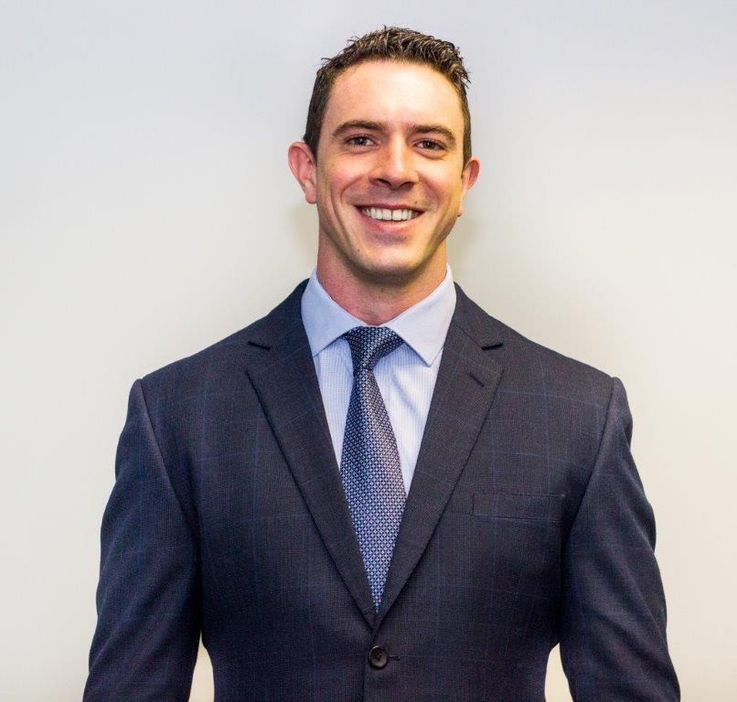 Man in a blue suit smiling at the camera