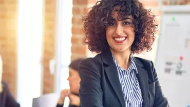 Professional woman smiling in an office meeting.