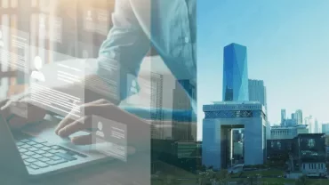 Person typing on laptop with digital profiles overlayed next to a city skyline.