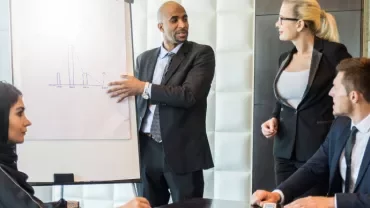 Business meeting with diverse professionals discussing a presentation.