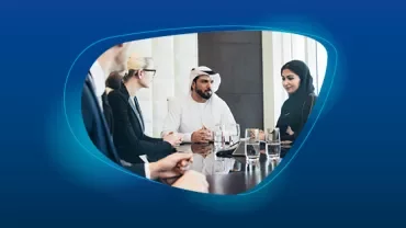 A diverse group of people in business attire having a meeting around a table.