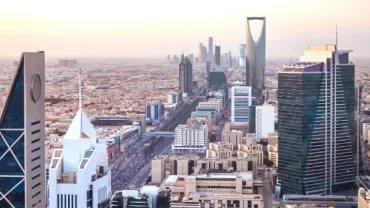 Skyline view of a modern city with tall skyscrapers during sunset.