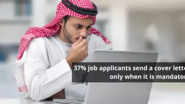 Man in traditional attire typing on a laptop with a quote about job applications.