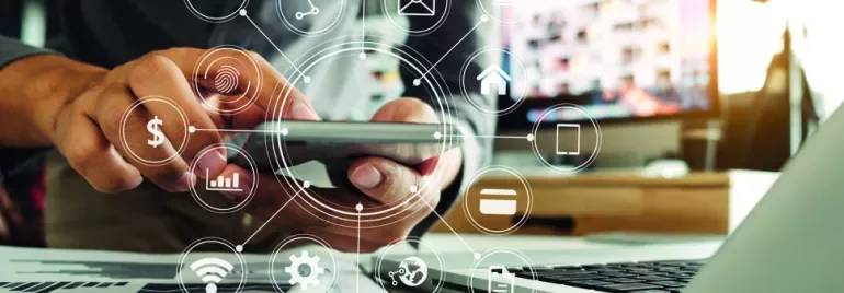 Person using smartphone with digital icons overlaying a laptop and desk.