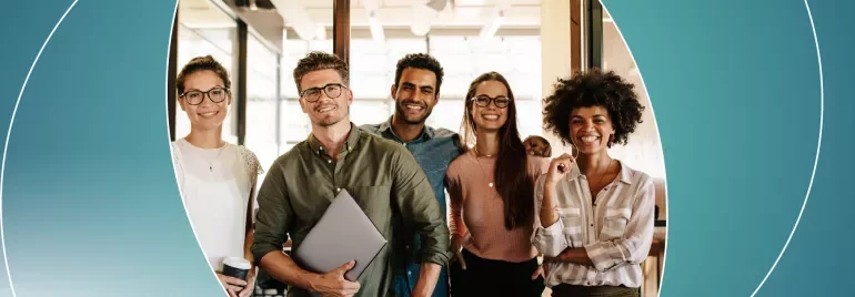 Group of five smiling professionals in an office