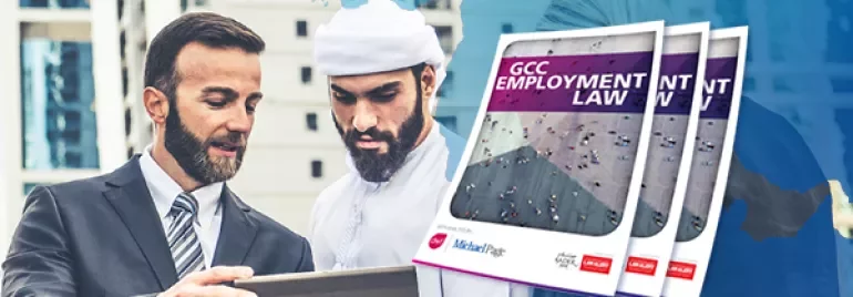 Two men in formal attire reviewing a document on a tablet outdoors.