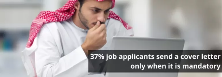 Man in traditional attire typing on a laptop with a quote about job applications.