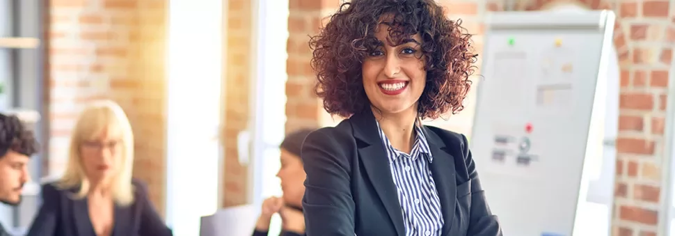 Professional woman smiling in an office meeting.