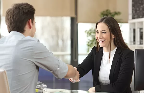 Business people shaking hands in an office setting.