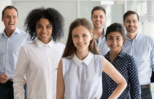 Diverse group of professionals smiling in an office setting.