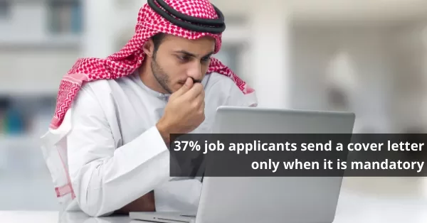 Man in traditional attire typing on a laptop with a quote about job applications.